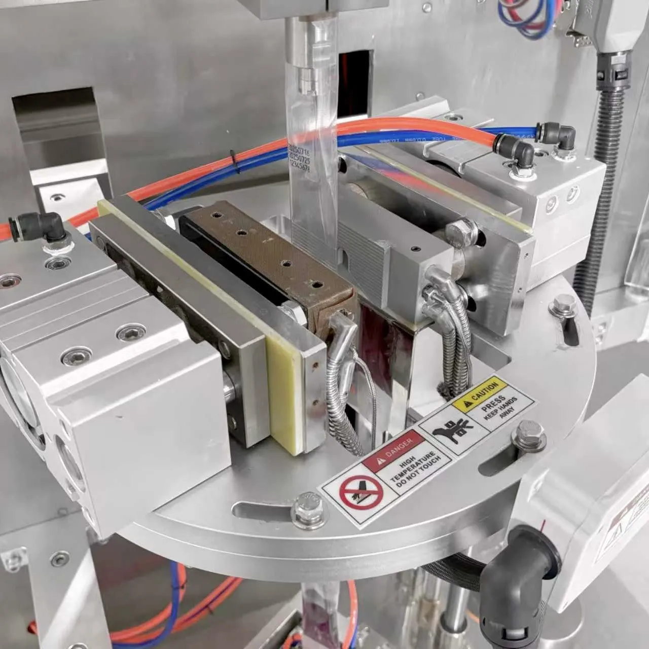 Vista detallada del sistema de llenado de líquidos y estructura de sellado de la máquina envasadora de jugo de uva.